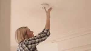 femme fixant son détecteur fireangel sans percer